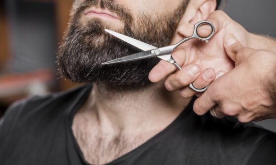 hombre se corta la barba con tijera